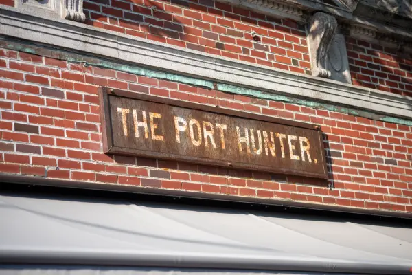 The weathered "The Port Hunter" sign on brick, Edgartown
