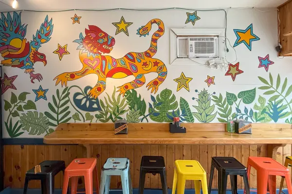 Counter stools under the tiger mural at Tigerhawk Sandwich Co.