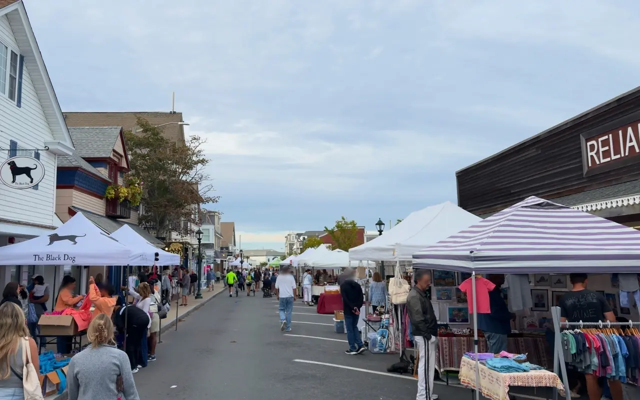 Crowd walking down a closed Circuit Avenue between Black Dog tents and craft vendor tents
