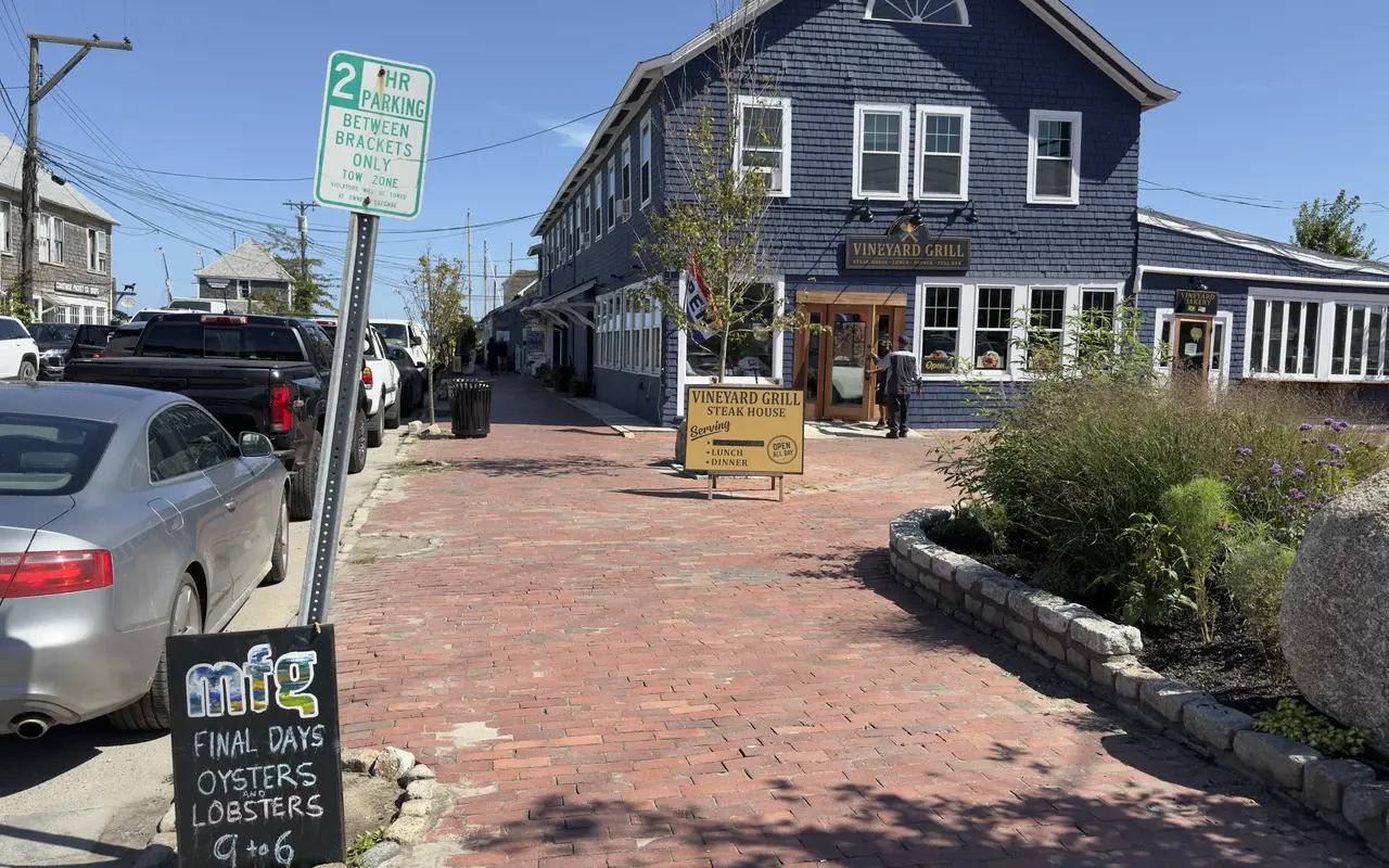 The Vineyard Grill, a blue-shingled Brazilian steakhouse on Beach Street Extension in Vineyard Haven, with its sandwich board on the brick sidewalk