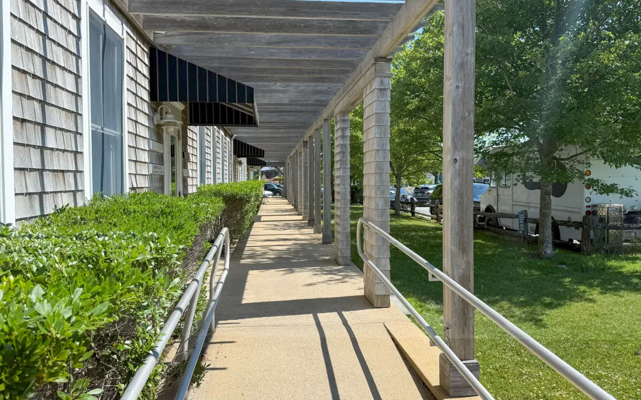 A long covered walkway beside shingled shops on Beach Road in Vineyard Haven