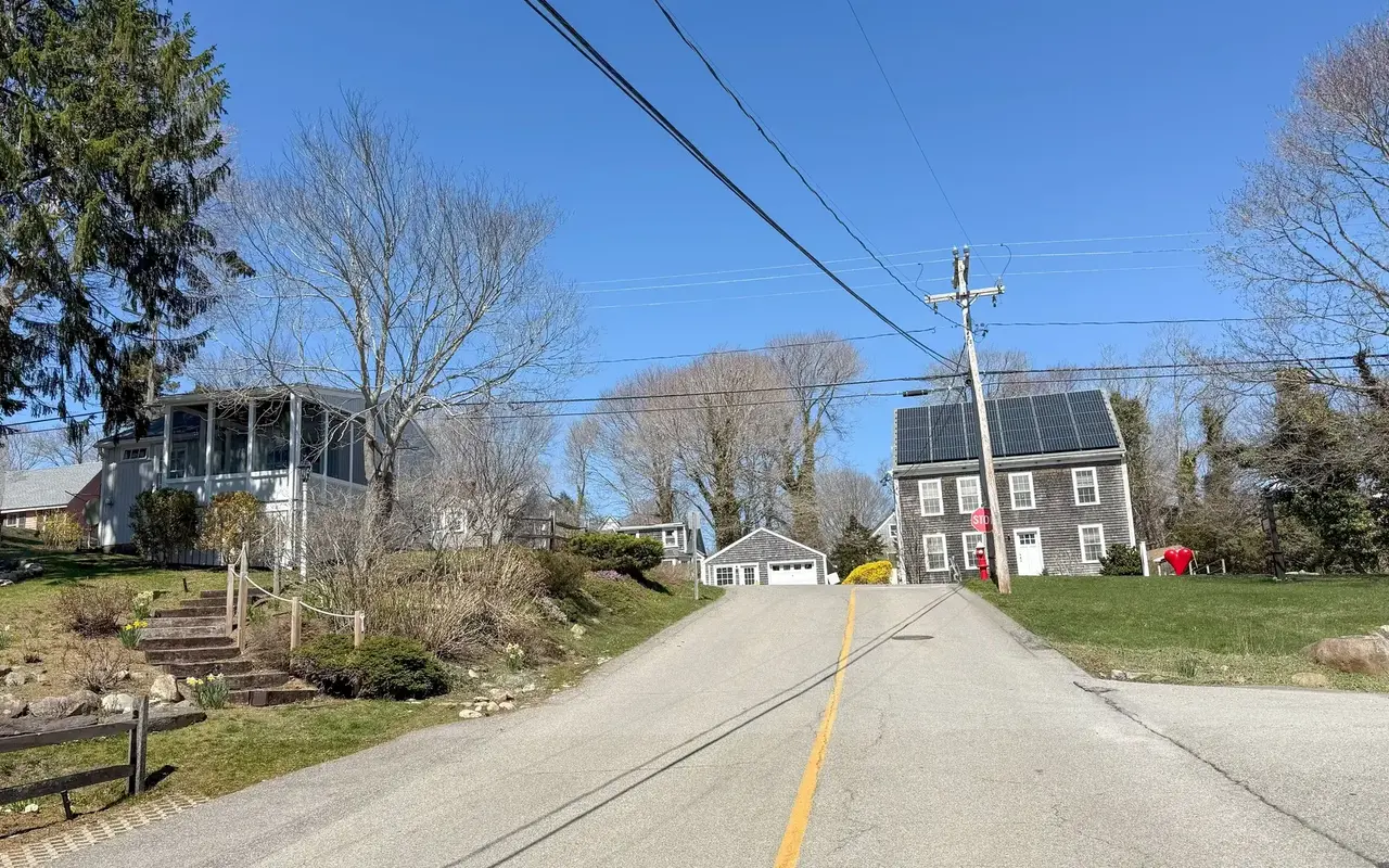 Quiet residential street in Vineyard Haven in April with bare trees and shingled houses