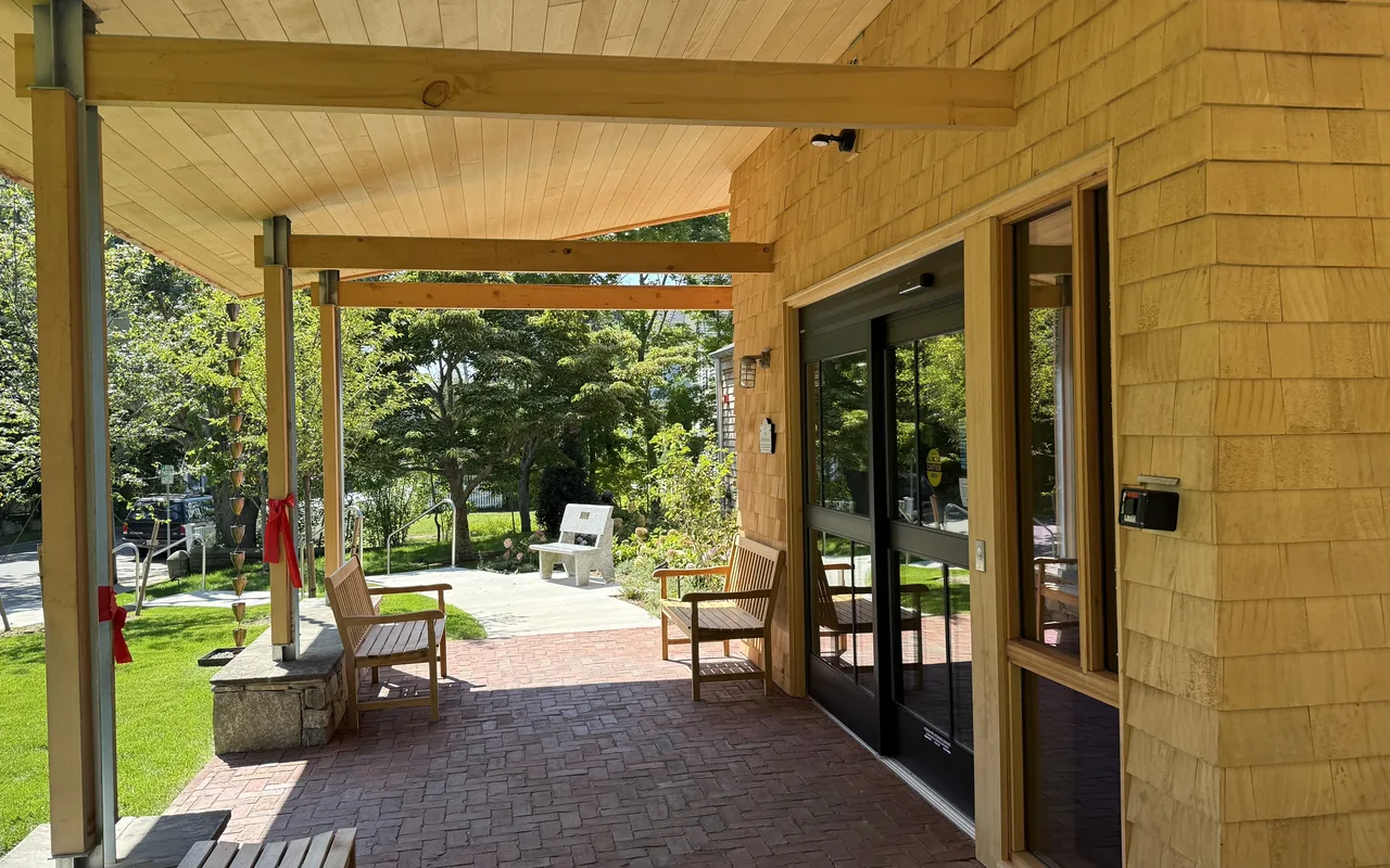 The new wooden entrance porch of the Vineyard Haven Public Library with benches and glass doors