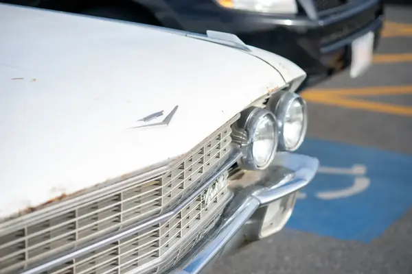 A vintage white sedan, chrome grille and twin headlights, parked in Oak Bluffs