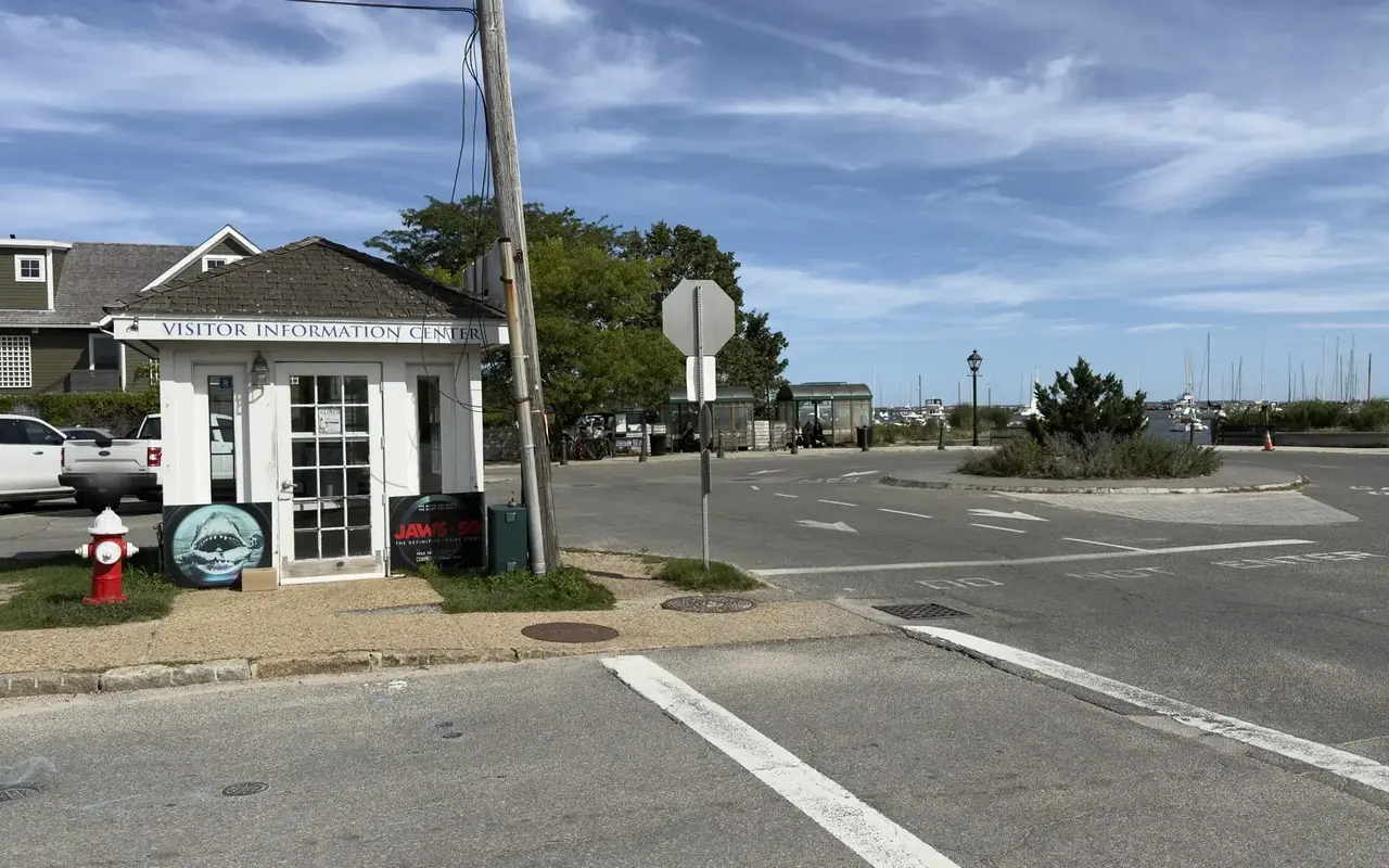 Closed white Visitor Information Center kiosk by the Vineyard Haven ferry terminal with two Jaws 50 posters leaning against it