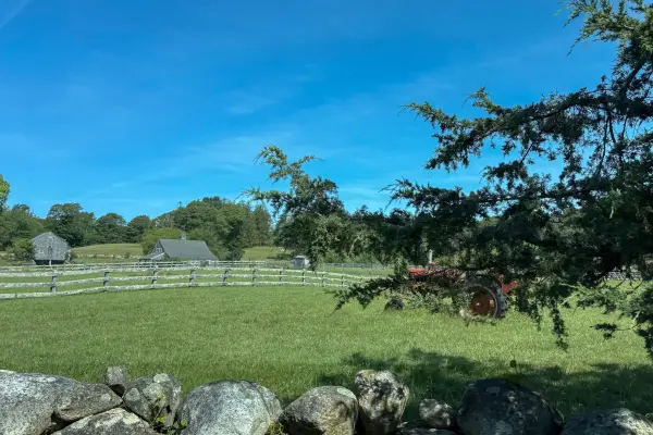 Tractor, stone wall and split-rail fence