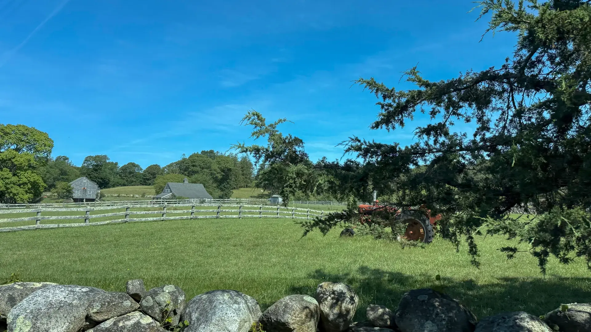 Tractor, stone wall and split-rail fence
