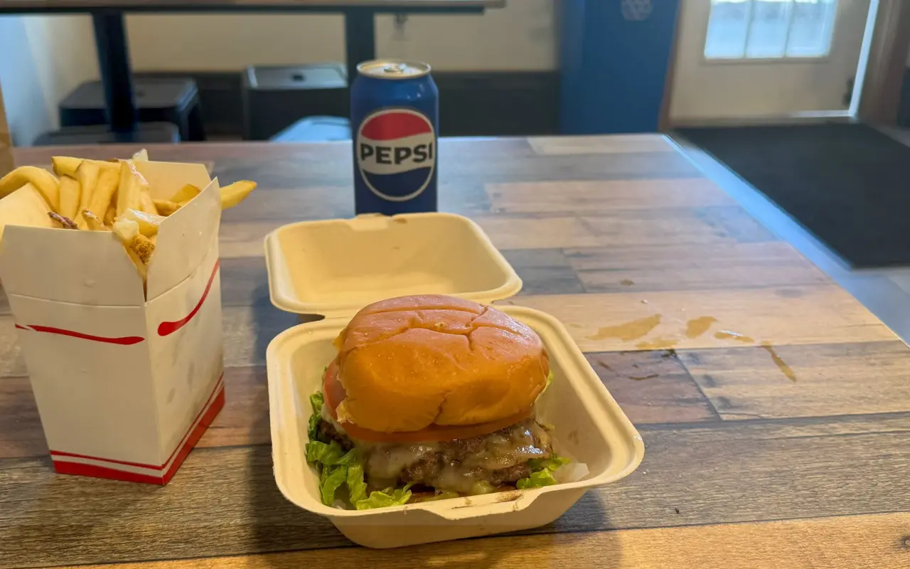 Smash burger with melted cheese and a box of french fries at Wicked Burger in Edgartown