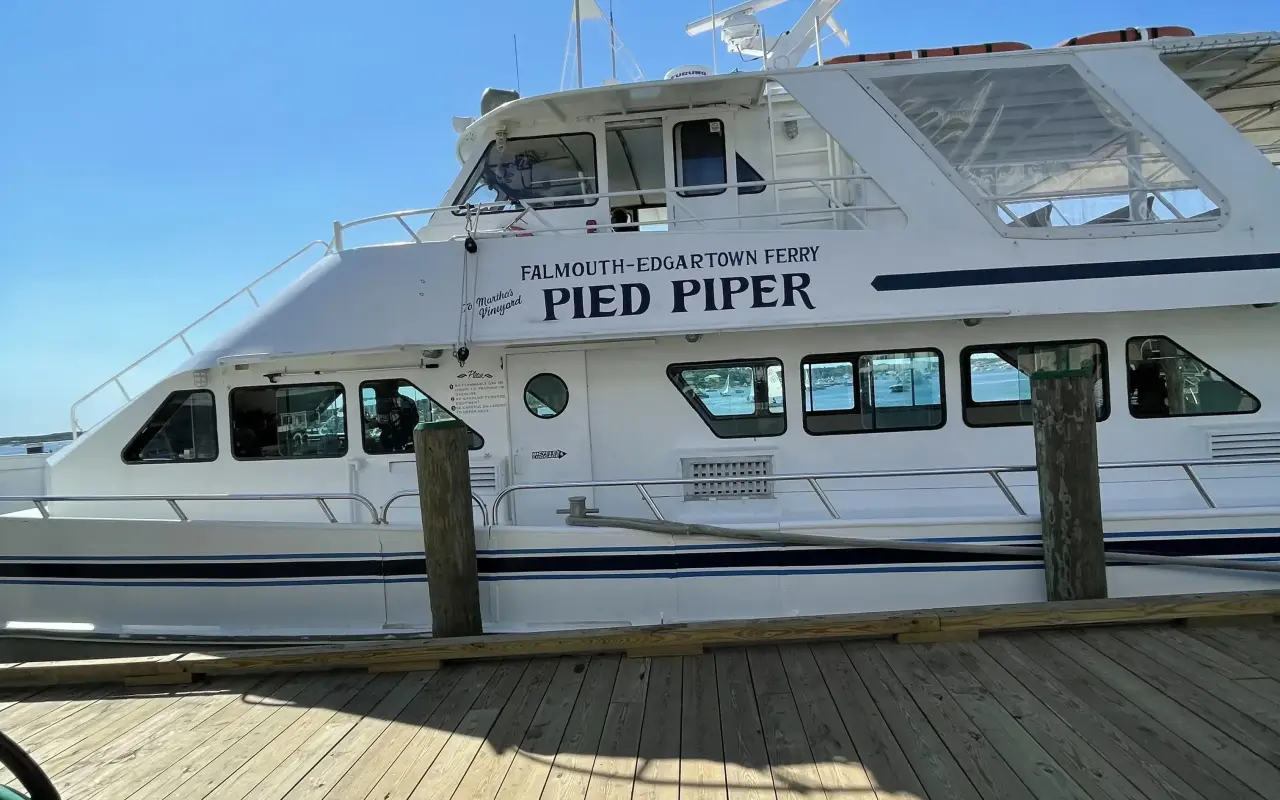 The white Falmouth to Edgartown ferry Pied Piper tied up at a wooden dock in Edgartown