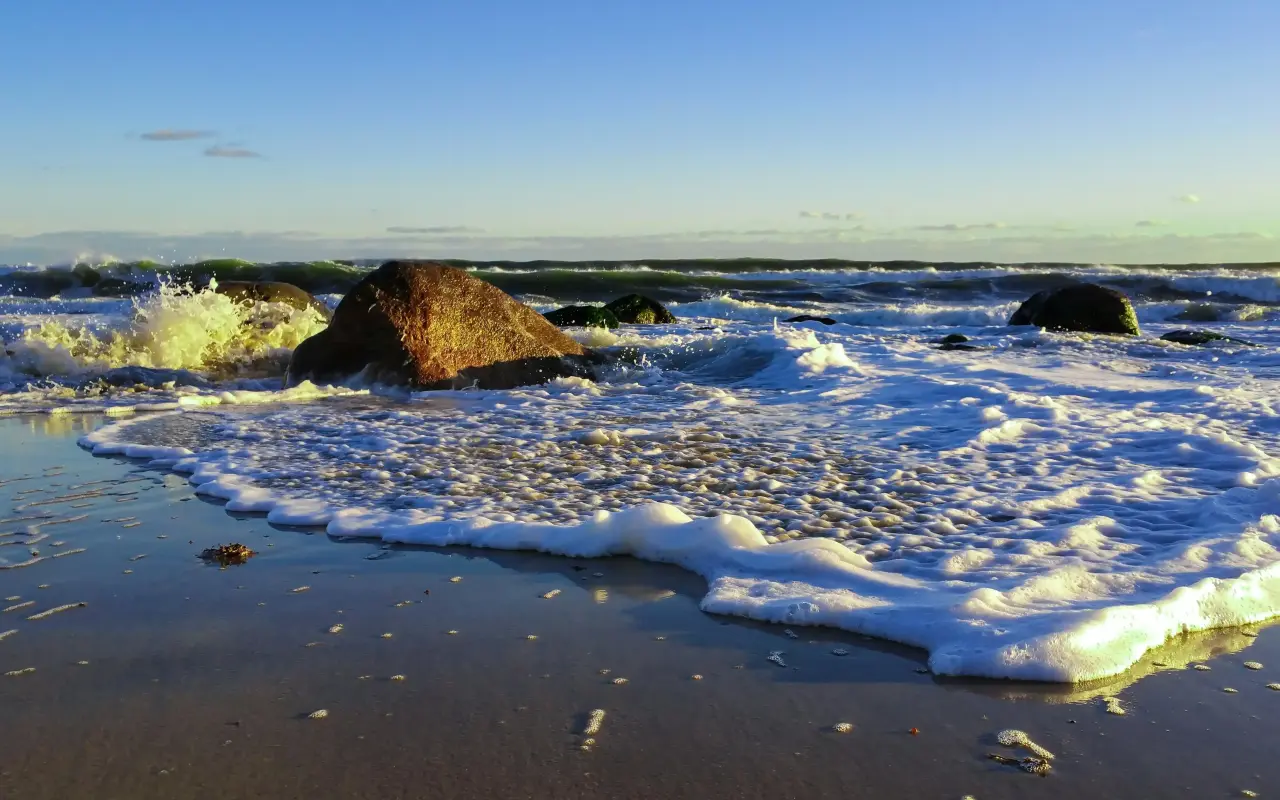 Foam from an Atlantic wave washing over rocks at Lucy Vincent Beach
