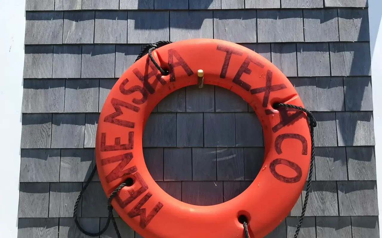 Menemsha Texaco life ring on a shingled wall at the harbor