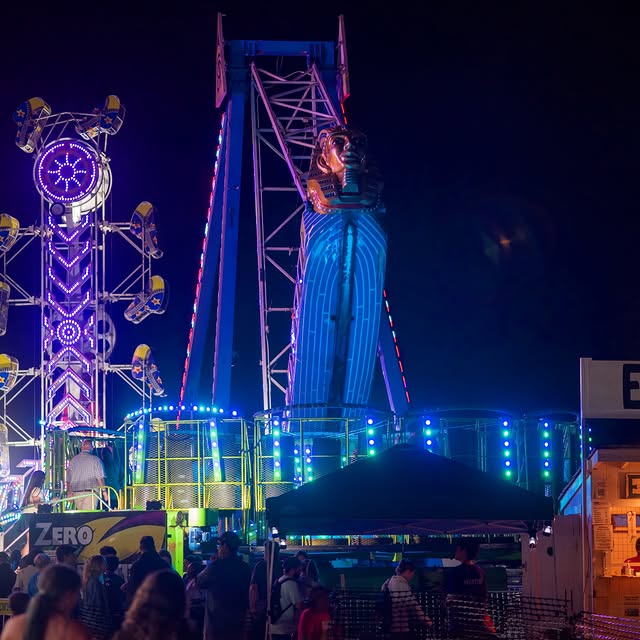 Ag Fair night in West Tisbury. Ferris wheel lit up, popcorn machine going, prize booths packed, kids...