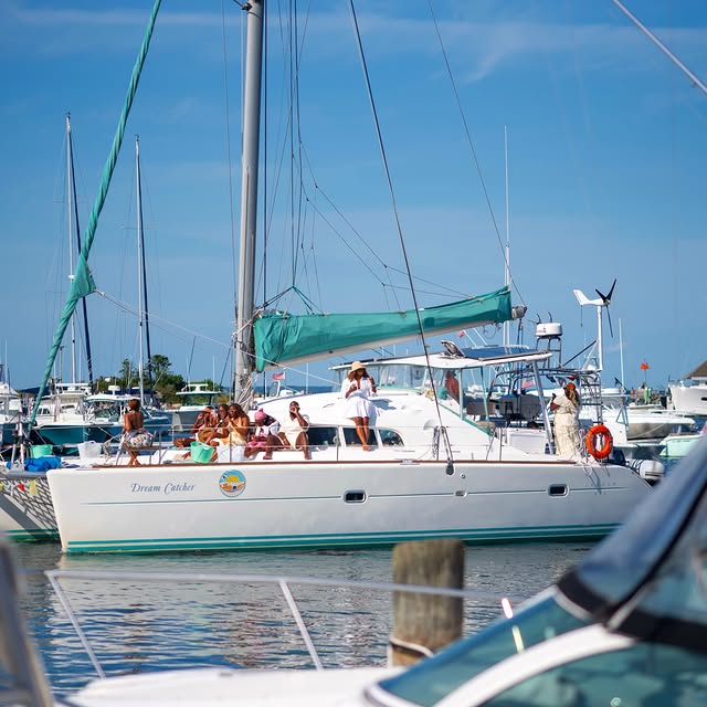 Oak Bluffs on a clear afternoon. A catamaran full of people easing out of the harbor, the VTA pullin...