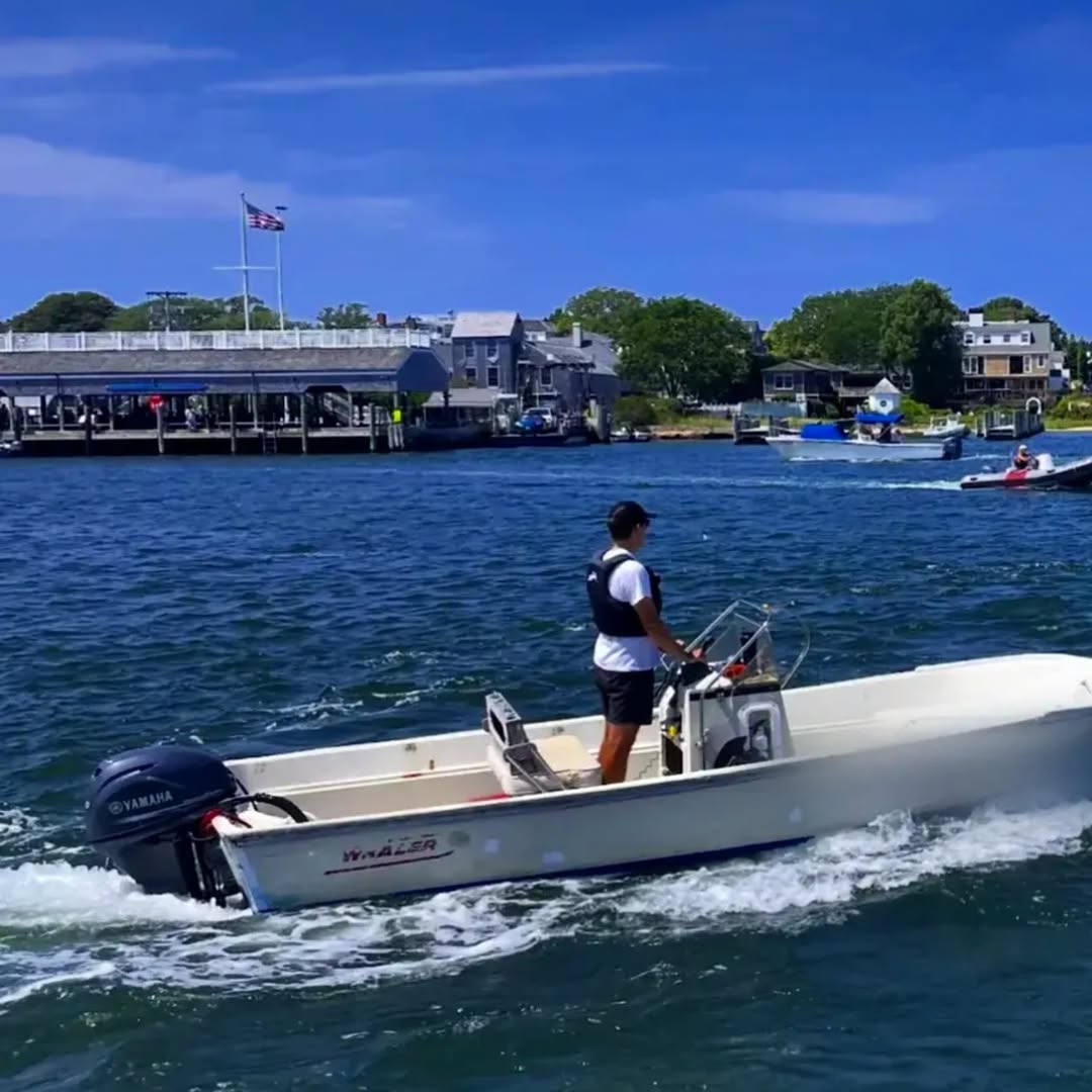A summer afternoon in Edgartown Harbor, with boats running back and forth across the channel to Chap...