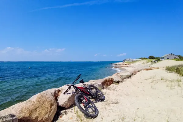 Bike resting on the rocks along a sunny shoreline