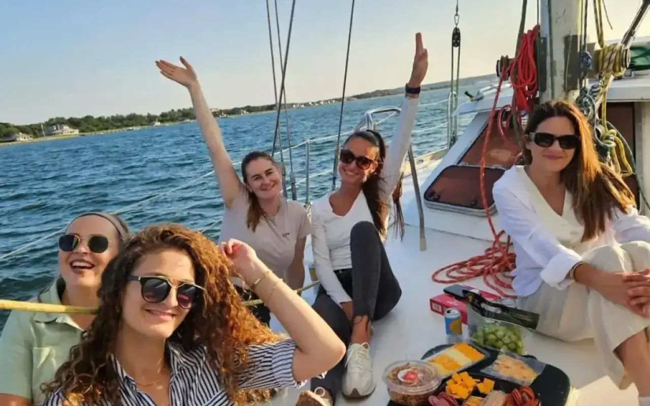 A group sitting on the deck of a sailing charter off Martha’s Vineyard