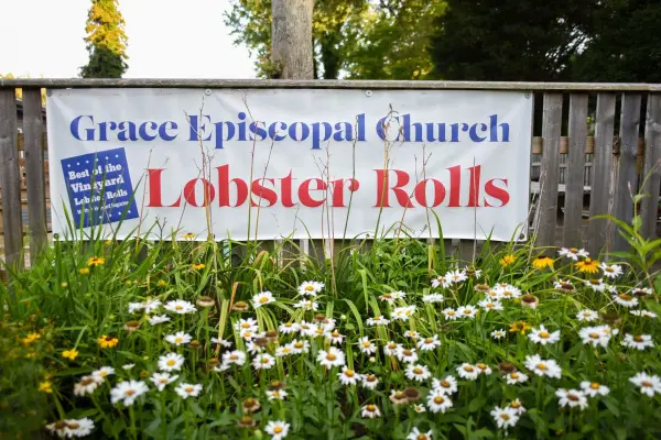 Grace Episcopal Church lobster rolls banner above the daisies