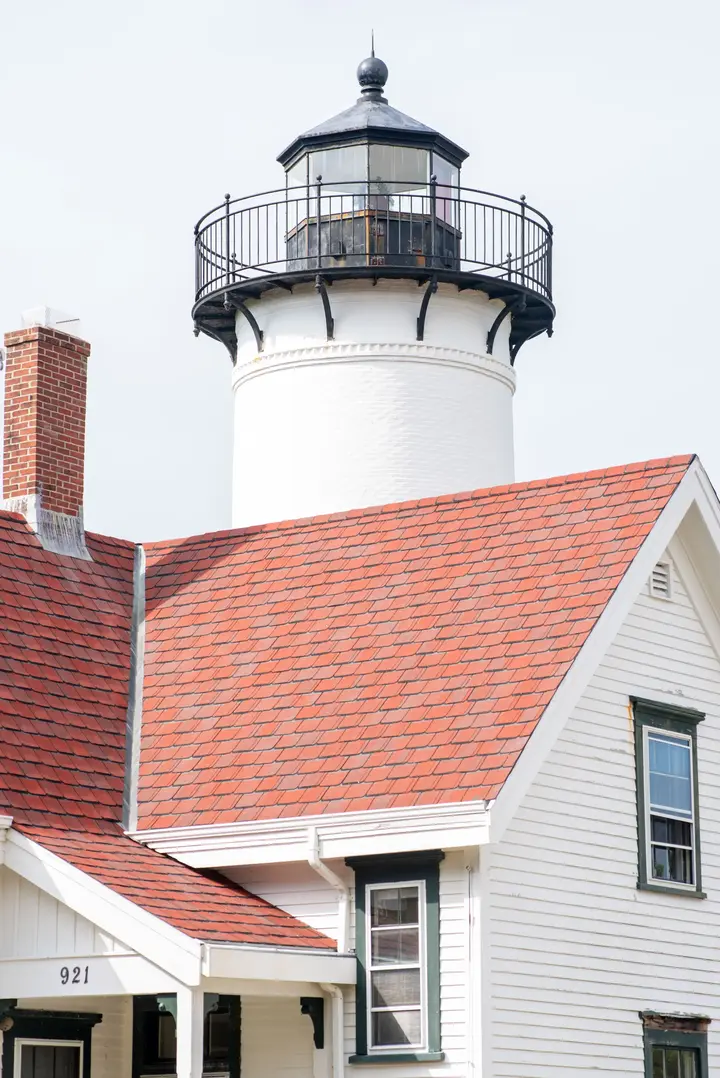 West Chop Lighthouse rising above the red tiled roof of the keeper's house in Vineyard Haven